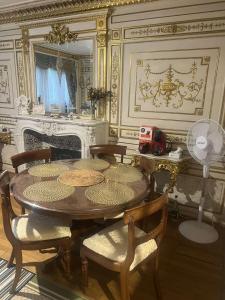 a dining room with a wooden table and chairs at Cozy Nice Apartment Room Free Wi-Fi an parking in Asnières-sur-Seine