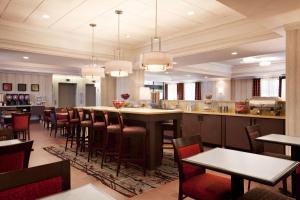 un restaurante con un bar con mesas y sillas en Hampton Inn by Hilton Boston/Cambridge, en Cambridge