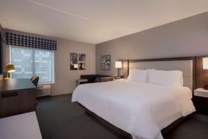 a hotel room with a large bed and a window at Hampton Inn by Hilton Boston/Cambridge in Cambridge