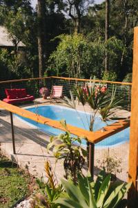 a swimming pool with a wooden bench next to it at Recanto de Encantos in Campos do Jordão