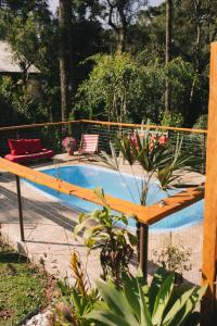una piscina con un banco de madera al lado en Recanto de Encantos, en Campos do Jordão