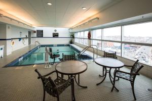 a swimming pool with tables and chairs in a building at Hampton Inn & Suites Boston Crosstown Center in Boston