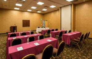 una sala conferenze con tavoli e sedie rosa e un podio di Hampton Inn & Suites Boston Crosstown Center a Boston
