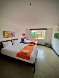 HOTEL RIVERA CENTRAL في بوكارامانغا: غرفة نوم كبيرة بسريرين ونافذة
