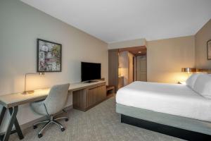 a hotel room with a bed and a desk with a computer at Hilton Garden Inn Boston Logan Airport in Boston