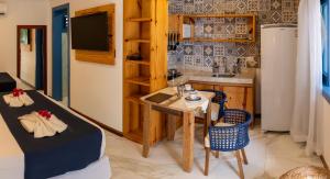 um quarto com uma mesa e uma cozinha com um lavatório em Vila Maria Pousada em Jericoacoara