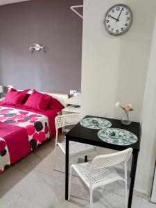 - une chambre avec un lit, une table et une horloge dans l'établissement Apartamentos Carrillo 6, à Santa Cruz de Tenerife