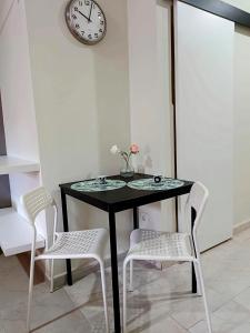 stół z dwoma krzesłami i zegarem na ścianie w obiekcie Apartamentos Carrillo 6 w mieście Santa Cruz de Tenerife