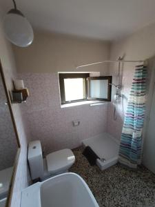 a bathroom with a sink and a toilet and a window at Apartamento en Terrades, Empordà in Terrades