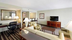 a hotel room with a couch and a desk at Hampton Inn Boston-Natick in Natick