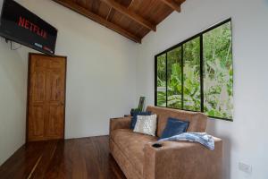 a living room with a couch and a large window at Casa Curré Monteverde in Monteverde Costa Rica