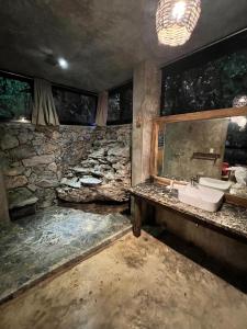 a bathroom with a sink and a stone wall at Taino Beach Lofts in El Valle