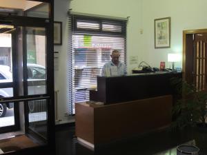 un hombre parado en una caja registradora en una tienda en Hotel Europa, en Girona