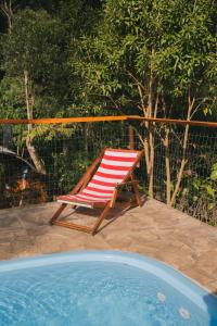 krzesło siedzące na patio obok basenu w obiekcie Recanto de Encantos w mieście Campos do Jordão