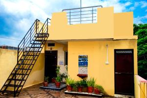 a yellow house with a staircase on it at Mangal kripa homestay in Ujjain