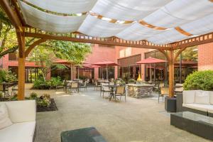 a patio with tables and chairs under a wooden pergola at DoubleTree by Hilton Boston-Andover in Andover