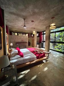 a large bedroom with a large bed with red pillows at Taino Beach Lofts in El Valle