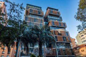 ein hohes Gebäude mit Palmen davor in der Unterkunft GHL Hotel Bioxury in Bogotá