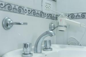 a bathroom sink with a faucet and a mirror at Fenix Apart in Concepción del Uruguay +31 photos