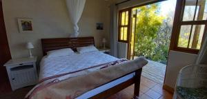 a bedroom with a bed and a large window at Willow's Rest in Barrydale
