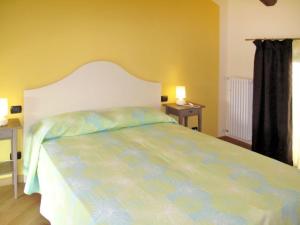um quarto com uma cama grande e uma cabeceira branca em Ca' Mia - Casa vacanze nelle vigne del Barolo em Serralunga d'Alba