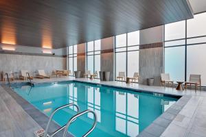 a swimming pool with tables and chairs in a building at Hampton Inn Salem, Ma in Salem