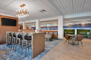 a restaurant with a bar and tables and chairs at Hampton Inn Salem, Ma in Salem