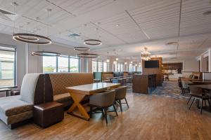 a lobby with a waiting room with tables and chairs at Hampton Inn Salem, Ma in Salem