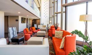 una hall con divani e sedie arancioni di The Verve Boston Natick, Tapestry Collection by Hilton a Natick