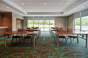 a conference room with tables and chairs and windows at Home2 Suites By Hilton Walpole Foxborough in Foxborough
