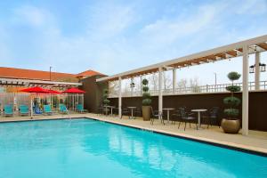 a swimming pool with tables and chairs on a building at Home2 Suites By Hilton Beaumont, Tx in Beaumont