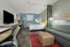 博蒙特Home2 Suites By Hilton Beaumont, Tx的配有床和沙发的酒店房间