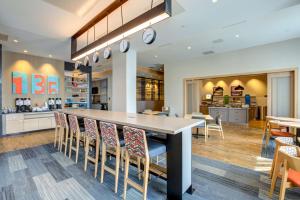 a kitchen and dining room with a large table and chairs at Hampton Inn & Suites Boston/Waltham in Waltham