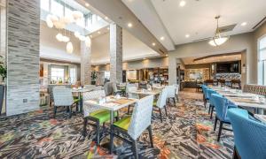 uma sala de jantar com mesas e cadeiras num restaurante em Hilton Garden Inn Beaumont em Beaumont