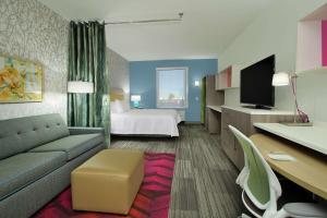 Habitación de hotel con sofá y cama en Home2 Suites By Hilton Port Arthur, en Port Arthur