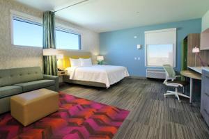 a hotel room with a bed and a couch at Home2 Suites By Hilton Port Arthur in Port Arthur