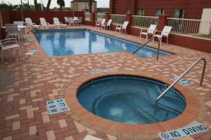 una gran piscina con sillas y sillas alrededor en Hampton Inn and Suites-Brownsville, en Brownsville