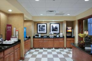a kitchen with wooden cabinets and a checkered floor at Hampton Inn and Suites-Brownsville in Brownsville