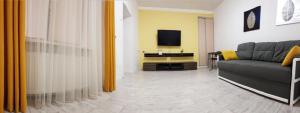 a living room with a couch and a tv at Austrian Lviv Apartments in Lviv
