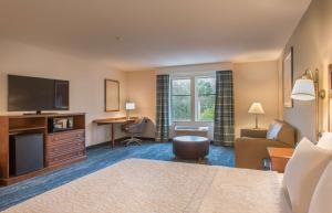 a hotel room with a bed and a television and a desk at Hampton Inn & Suites Jekyll Island in Jekyll Island
