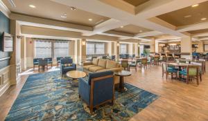 a lobby of a hotel with tables and chairs at Hampton Inn & Suites Jekyll Island in Jekyll Island