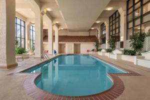 a large swimming pool in a building at Embassy Suites Baton Rouge in Baton Rouge