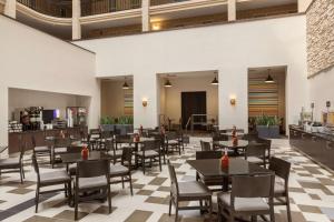 um restaurante com mesas e cadeiras e um piso xadrez em Embassy Suites Baton Rouge em Baton Rouge