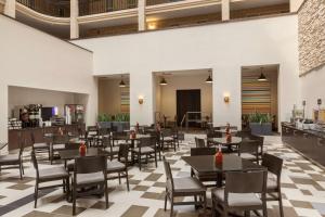 a restaurant with tables and chairs and a checkered floor at Embassy Suites Baton Rouge in Baton Rouge