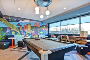 a pool table in a childrens room with a mural at Tru By Hilton Baton Rouge Citiplace in Baton Rouge