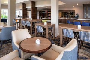 ein Restaurant mit Tischen und Stühlen und eine Bar in der Unterkunft Hilton Garden Inn Baton Rouge Airport in Baton Rouge