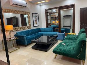a living room with blue couches and a mirror at Three Bedroom Villa in Lahore