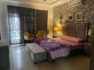a bedroom with a large bed and a chair at Three Bedroom Villa in Lahore
