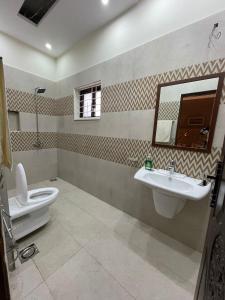 W łazience znajduje się toaleta, umywalka i lustro. w obiekcie Three Bedroom Villa w mieście Lahaur