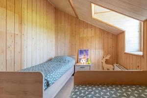a bedroom with a bed in a room with wooden walls at Les 4 bras Maison de vacances in Beauraing